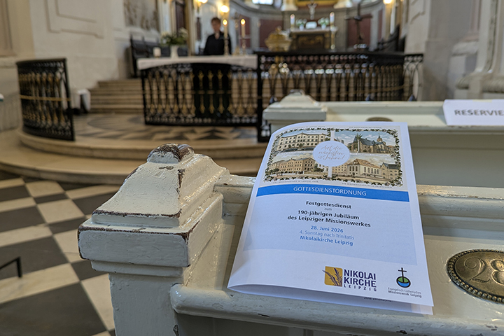 Bild aus der Leipziger Nikolaikirche. Das Programm zum Festgottesdienst liegt auf der Kirchenbank.