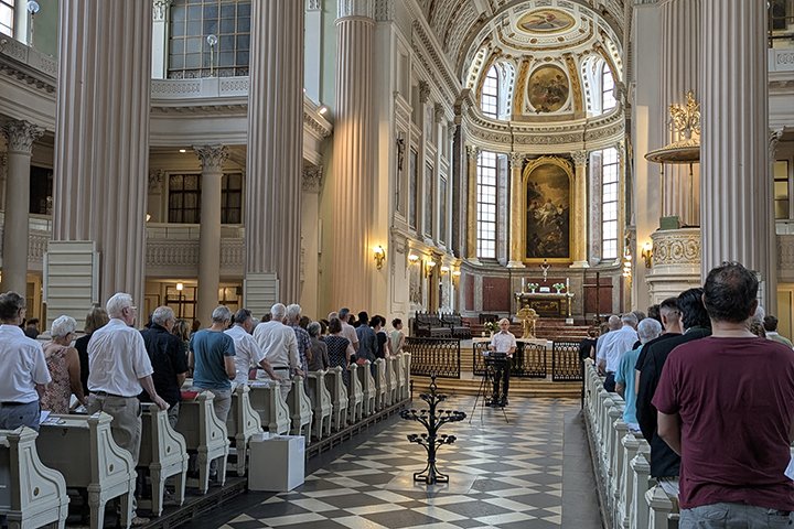 Festgottesdienst in der Leipziger Nikolaikirche, Blick von hinten ins Kirchenschiff. Die Bänke sind gut gefüllt.
